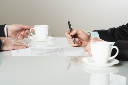 Businessmen are signing a contract, business contract detailsの写真素材