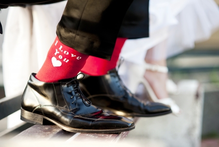 Groom s funny feet with love sign on red socks の写真素材