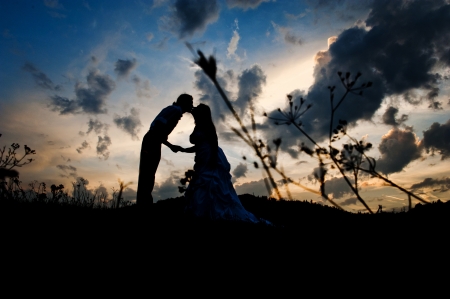 Silhouette of a young bride and groom on sunset backgroundの写真素材