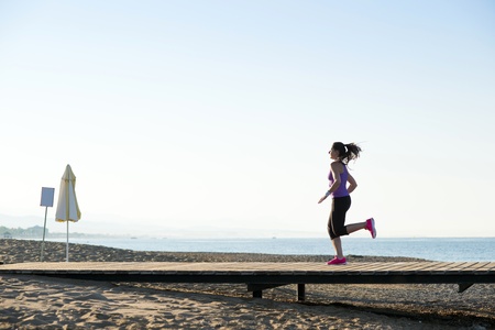 Young woman is running in sunny natureの写真素材