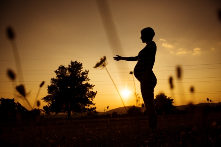 Silhouette of pregnant woman in the sunsetの写真素材