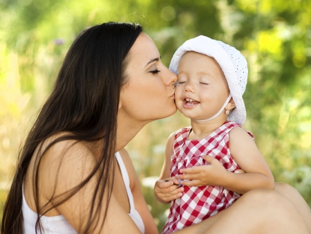 Young and beautiful mother is playing with her cute daughterの写真素材