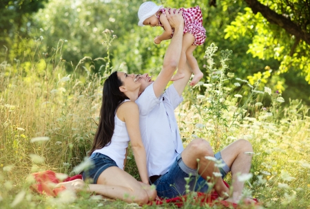 Happy young family spending time together in green nature の写真素材