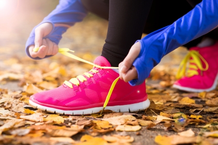 Close up of feet of a runner running in autumn leaves training exerciseの写真素材