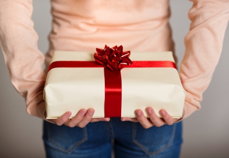 Female holding gift box with ribbon in her hands