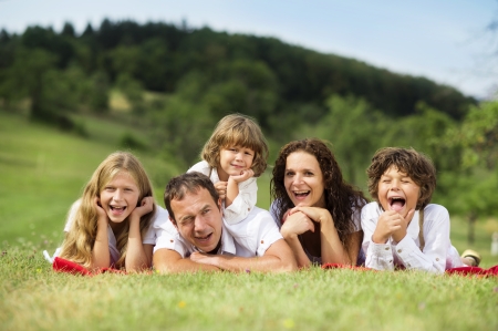Big family is relaxing together in green natureの写真素材