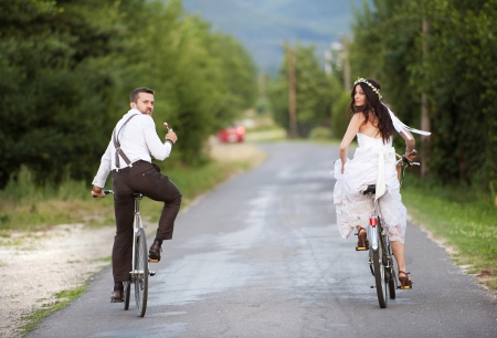Beautiful bride and groom riding on the bikesの写真素材