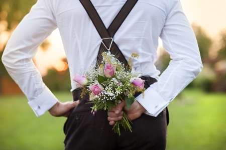 Part of the groom holding wedding bouquet in handの写真素材