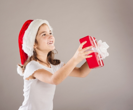 Happy small girl in santa hat with christmas giftの写真素材