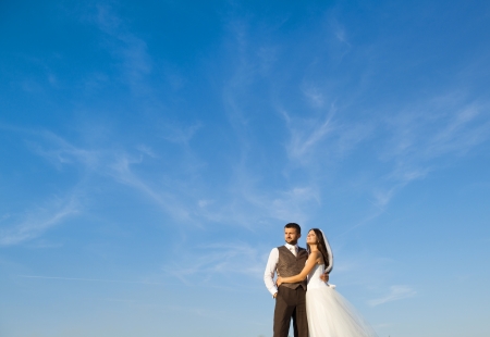 Newly married couple portrait with blue sky in summer fieldの写真素材