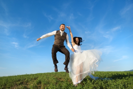Newly married couple portrait with blue sky in summer fieldの写真素材