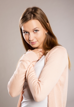 Beautiful young woman posing in studio over a gray backgroundの写真素材
