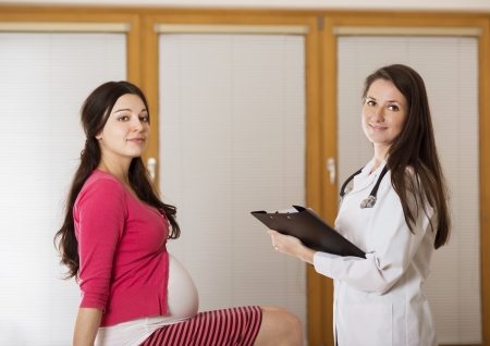 Young pregnant woman with doctor in ambulance の写真素材