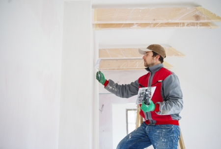 Construction worker is painting the wall in new houseの写真素材