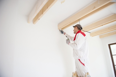 Construction worker is painting the wall in new houseの写真素材
