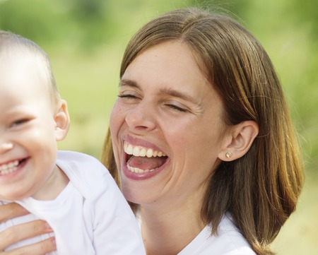 Mother and her little son are playing together outsideの写真素材