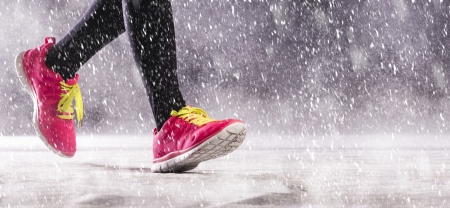 Athlete woman is running during winter training outside in cold snow weather の写真素材