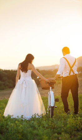 Beautiful bride and groom wedding portrait with white bikeの写真素材