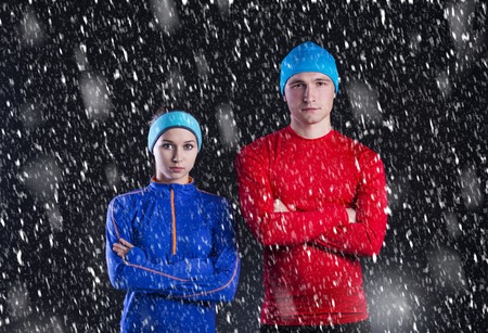 Young fitness athletes are standing outside in cold winter night  Snow is falling around them の写真素材