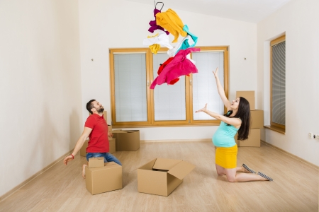 Young couple is moving into new house with lot of boxes  Woman is pregnant の写真素材