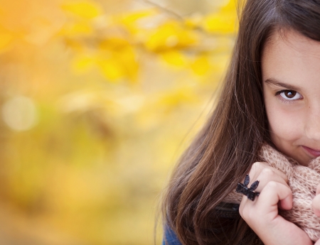 Cute girl in warm autumn clothes relaxing colorful autumn natureの写真素材