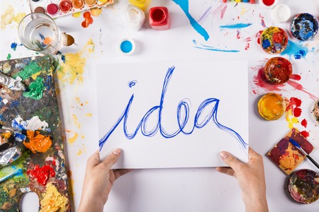 Creative idea concept with colorful paints over white paperの写真素材