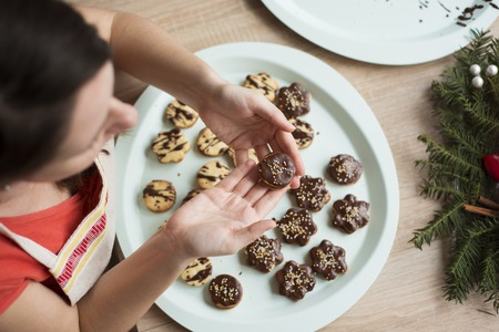 Woman is making christmas cakes in the kitchenの写真素材