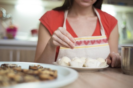 Woman is making christmas cakes in the kitchen