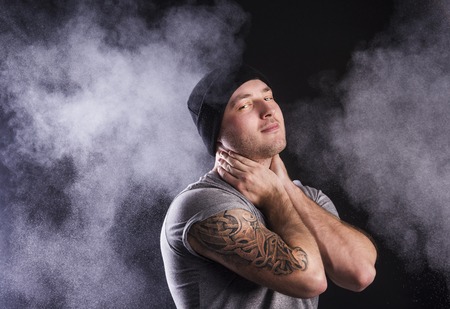 Handsome young man with tattoo, isolated on black の写真素材