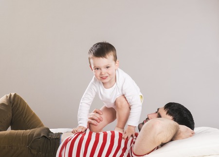 Portrait of a father with his son in bedの写真素材