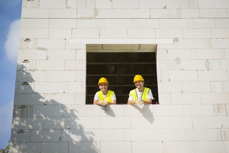 Builders are working on the top of house construction 