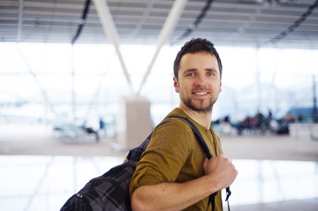 Young man is waiting at the airport for his flight  の写真素材
