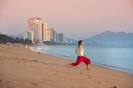 Sport active woman stretching and exercising at the city beach の写真素材