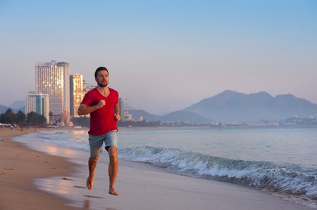 Sport active man running and exercising at the city beach の写真素材