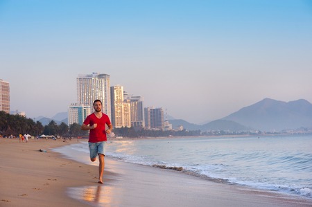 Sport active man running and exercising at the city beach の写真素材