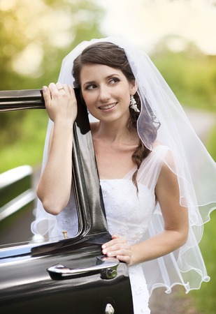 Beautiful Bride with retro car  Outdoor wedding portrait の写真素材