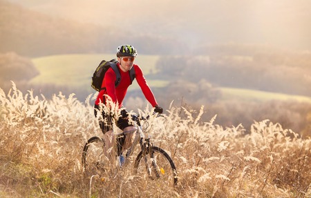 cyclist man riding mountain bike on outdoor trail in nature