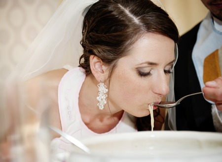 Bride and groom are eating at the wedding receptionの写真素材