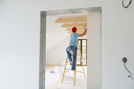 Man painting wall in new houseの写真素材