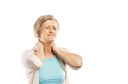 Senior woman suffering from neck pain, isolated on white backgroundの写真素材