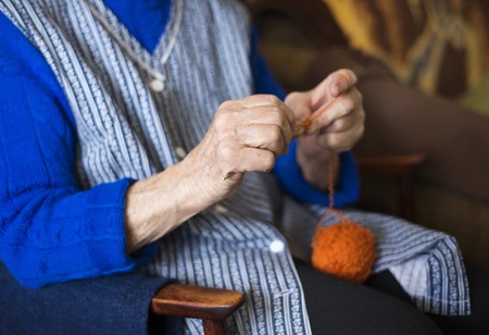 Hands of senior woman knitting with wool and knitting needlesの写真素材
