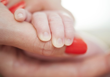 Closeup of newborn babyÂ´s hand holding motherÂ´s hand の写真素材