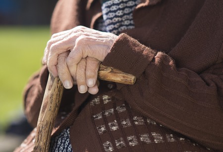 Detail of very old woman s hands holding walking stickの写真素材