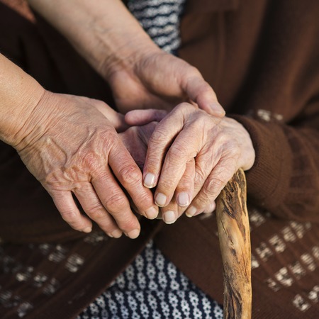 Closeup of caring woman holding female senior s handsの写真素材