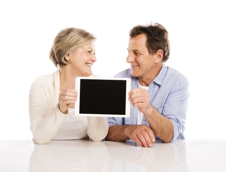 Senior couple using tablet, isolated on white backgroundの写真素材