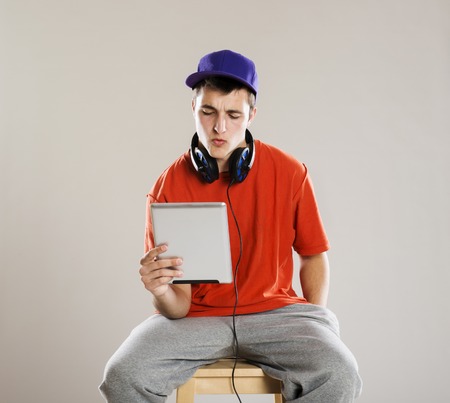 Handsome young man with digital tablet isolated in studioの写真素材