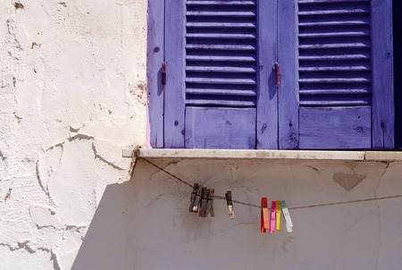 Closed blue window shutters and clothes pins on ropeの写真素材