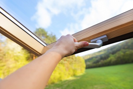 Beautiful nature view through roof skylight window in attic room の写真素材