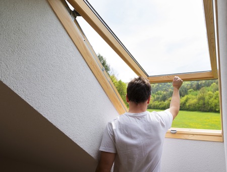 Beautiful nature view through roof skylight window in attic room の写真素材