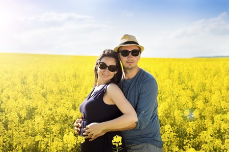 Spring outdoor portrait of young pregnant couple